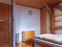 a kitchen with wooden cabinets and a bed in a room